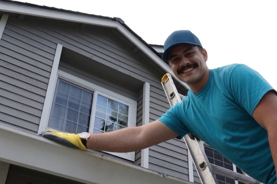 3 Amigos crew member cleaning a gutter